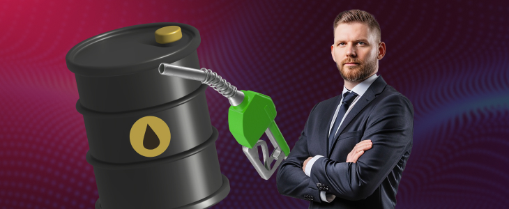 A businessman in a suit grips a barrel of oil, representing the influence of energy prices on forex markets.